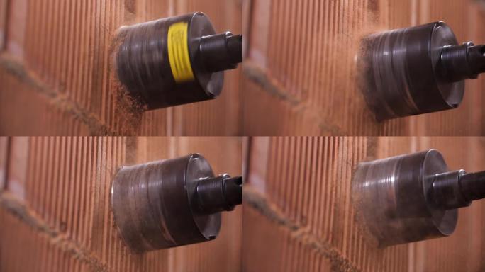 用电锤钻头工具封闭墙壁上的钻孔工艺，用于电源插座。库存镜头。用专业设备在红砖墙内打洞