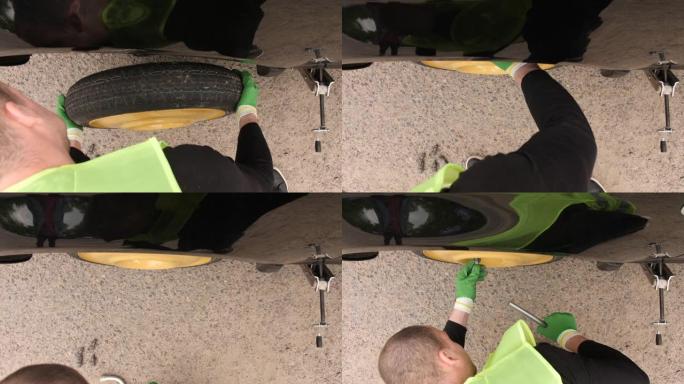 该男子在卸下轮胎后正在更换汽车轮胎。