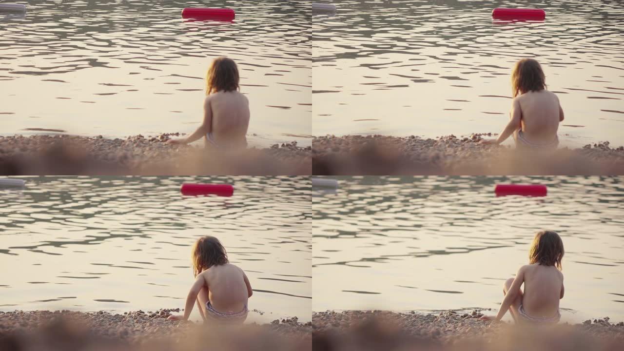小女孩在浅水里玩鹅卵石