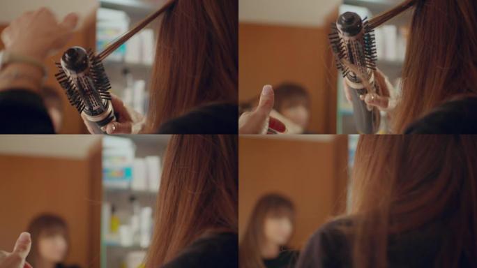 女人用电刷梳理头发。慢动作拍摄