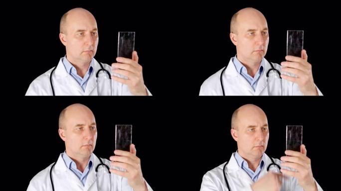 医生在黑色背景上使用透明智能手机上的触摸屏。穿着白大褂的医务工作者触摸未来的手机。现代高科技小玩意概