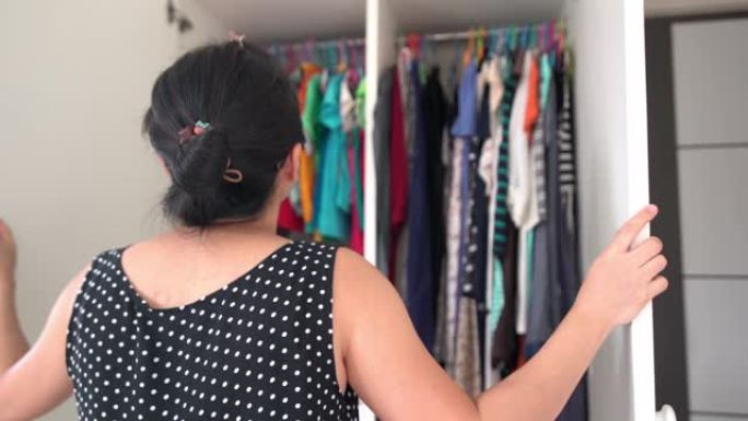 亚洲女性打开衣柜，寻找新的对齐方式