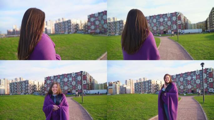 女人在公园散步的阳光视频。中年黑发，长长的黑发，在风中飘动，包裹着紫色格子，在相机中转身，走了，你可
