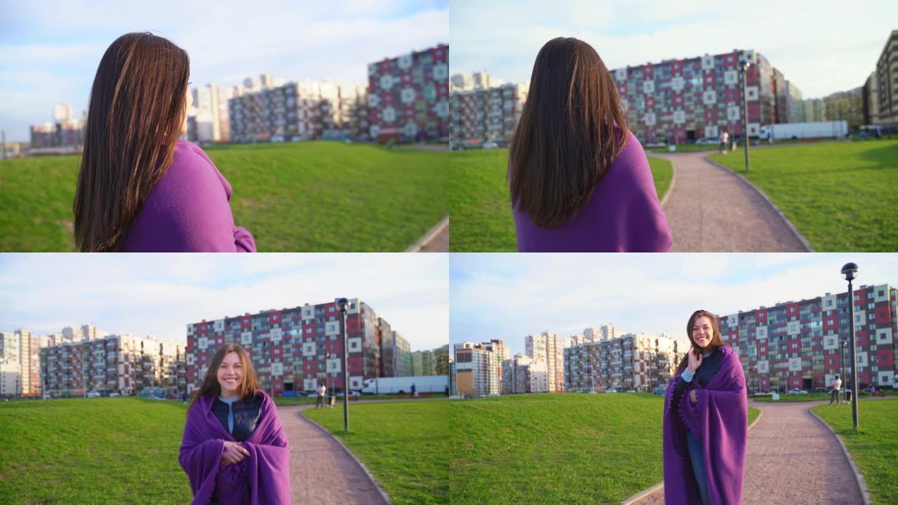 女人在公园散步的阳光视频。中年黑发，长长的黑发，在风中飘动，包裹着紫色格子，在相机中转身，走了，你可