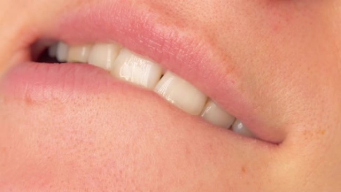 女人咬住嘴唇，变得角质或臀部。洁白牙齿的美丽微笑。