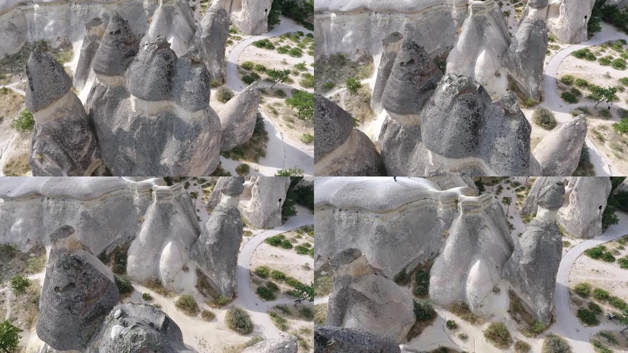 卡帕多西亚童话烟囱景观。4k上升空中无人机拍摄土耳其卡帕多西亚岩石屋村和岩层景观的洞穴屋