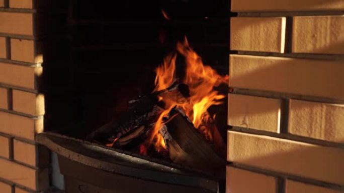 黄砖铸铁烧烤壁炉，燃烧橡木木柴手持拍摄阳光明媚的夏夜