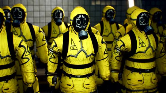 穿着黄色防护服的医生在工作日开始前排队。穿着细菌防护和防毒面具的人。