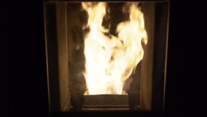家里有替代颗粒炉，里面有燃烧的火和木颗粒，用于加热房间和整个房子。颗粒炉中燃烧生物燃料产生的火焰