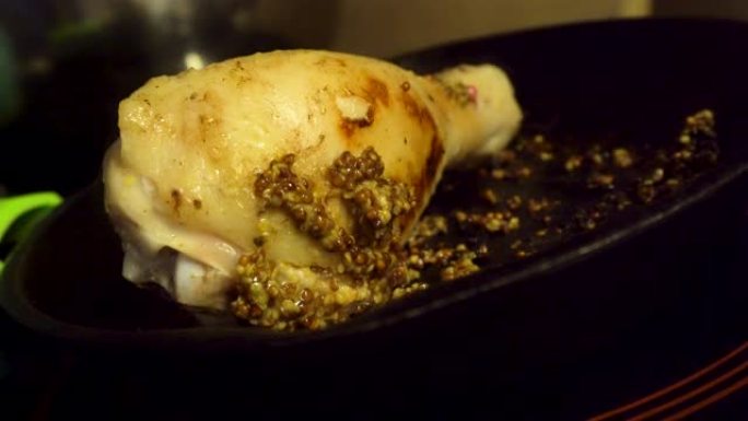 芥末籽特写鸡腿在铸铁锅中煮熟