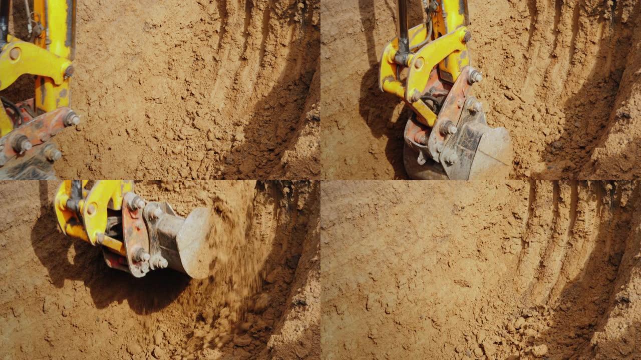 由强大的液压系统驱动的挖掘机铲斗清除沟渠中的土壤。管道铺设
