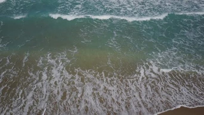 蓝绿色海浪席卷佛罗里达州海滨的棕榈滩
