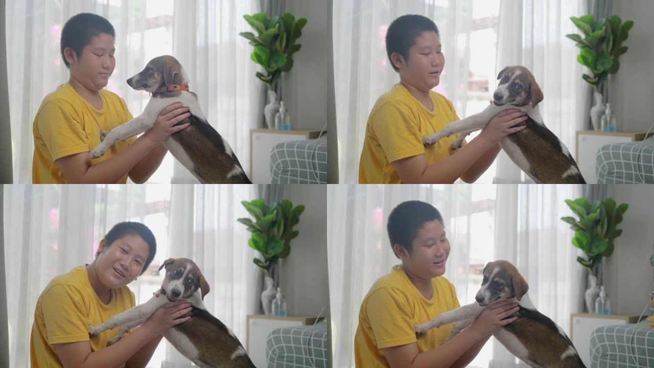 亚洲青春期男孩在家抱着狗，生活方式概念。
