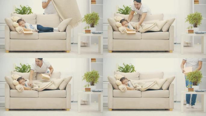 4k视频，爸爸用毯子盖住她的小女儿在沙发上。