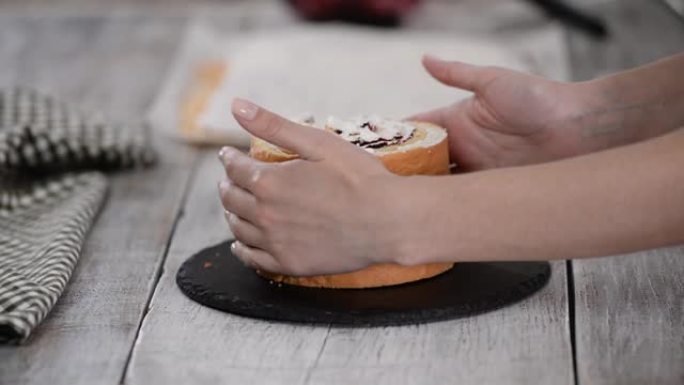 糕点厨师用垂直层和黑醋栗果酱制作海绵蛋糕。系列