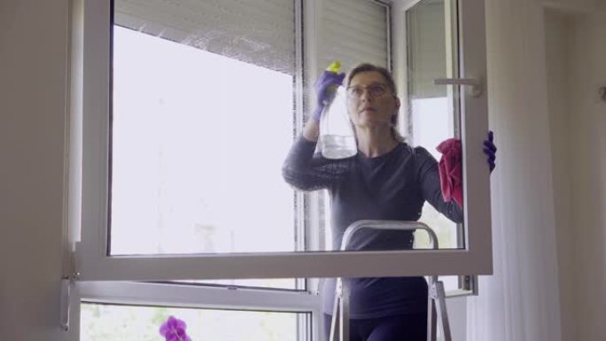 冠状病毒期间，高级妇女在家清洁窗户