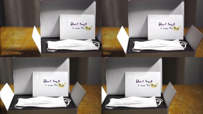 礼品盒中的防护口罩，桌上有手写明信片