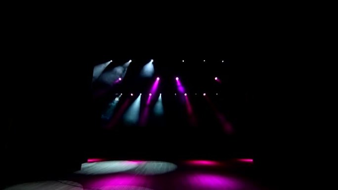舞台灯光在讲台上闪烁。有粉红色聚光灯的剧院的舞台。