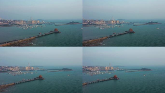 阳光明媚的夜晚青岛市著名的海滩湾码头宝塔拥挤码头空中全景4k中国
