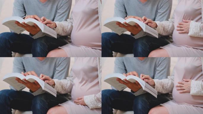 亲密的亚洲男人和孕妇在客厅里一起读书，心情愉快
