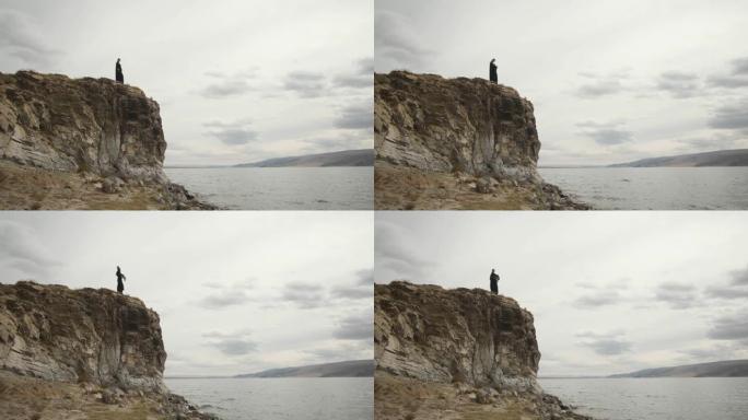 穆斯林妇女女孩站在山顶的悬崖边缘，大湖