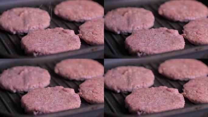 将胡椒粉撒在肉上，用于黑锅上的汉堡。