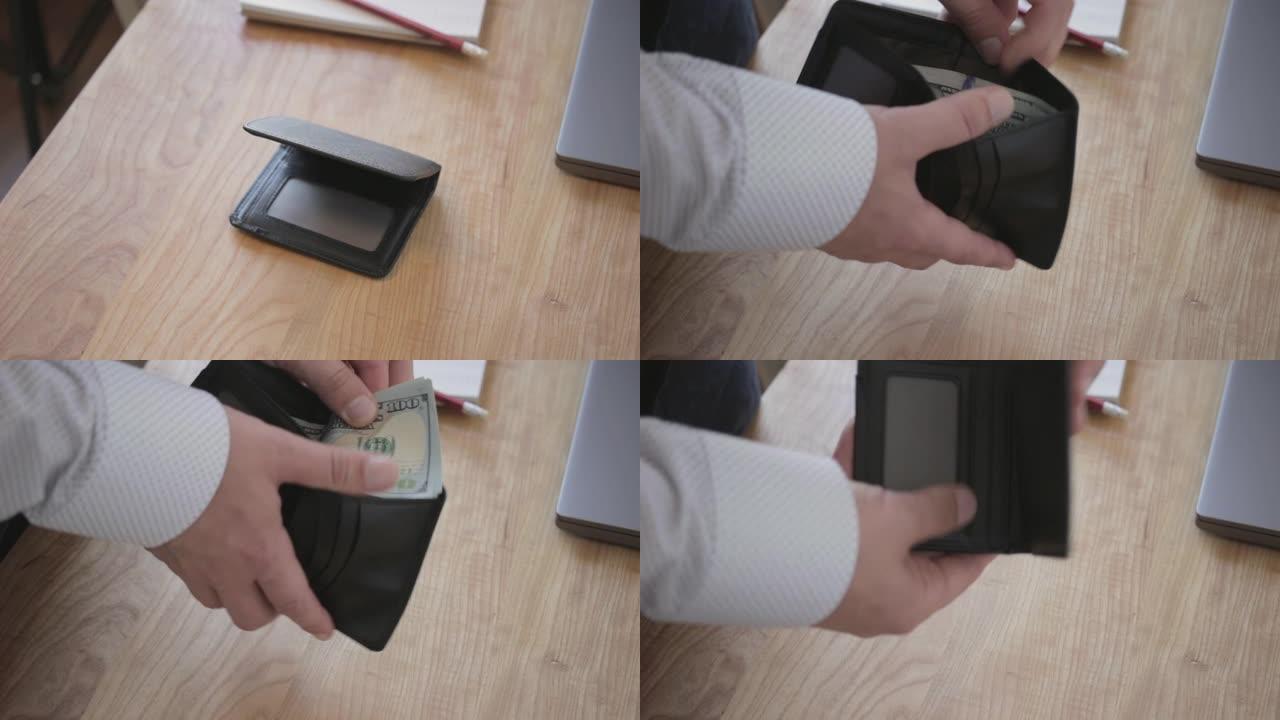 男从工作台上拿钱包，看着钱几百美元的皮夹，特写