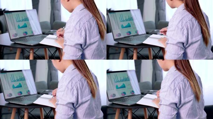 年轻的商务亚洲女性坐在工作场所用笔记本电脑写计划工作，女行政经理在上网本上浏览信息记录