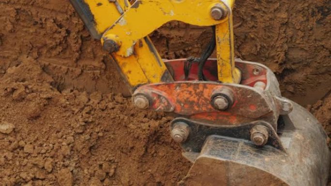 建筑工地的土方设备。挖掘机铲斗从沟渠中清除地面