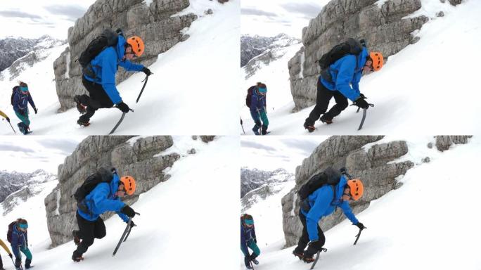 冬季登山者使用冰斧爬上雪山