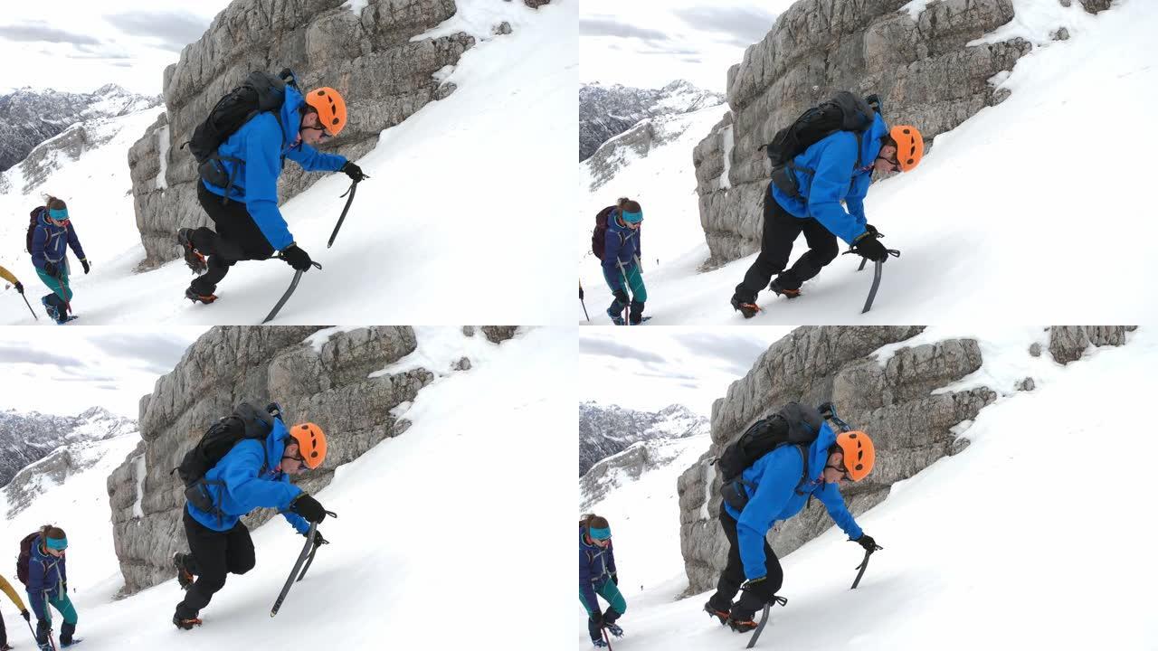 冬季登山者使用冰斧爬上雪山