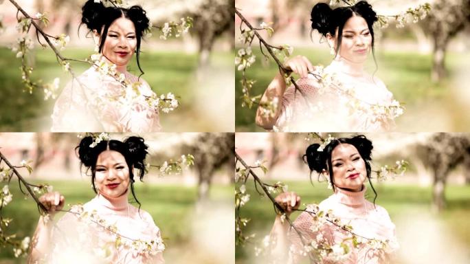 透过迷人的亚洲女士盛开的树枝在花园里眺望