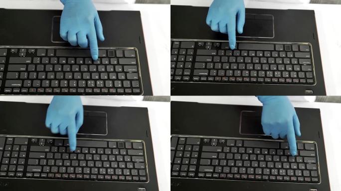 特写无法辨认的医生穿着蓝色防护手套在笔记本电脑上远程工作。