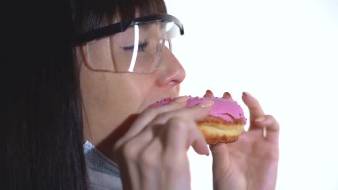 戴着医用口罩和护目镜的女人吃甜甜圈500fps