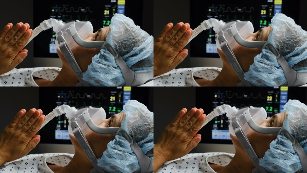 白人成熟的女人连接到呼吸机面罩上，双手一起抬头祈祷