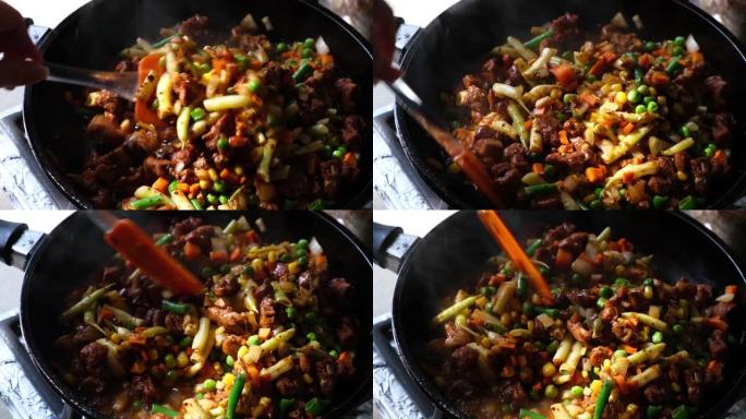 一块多汁的新鲜猪肉和蔬菜炖在煎锅上，用蒸汽特写。