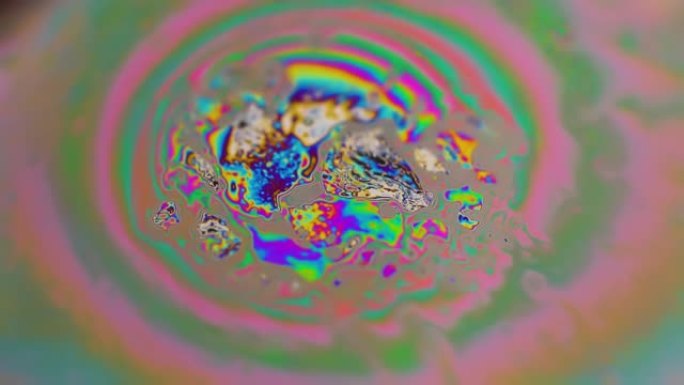 来自肥皂泡的迷幻抽象行星，肥皂泡上的光折射，肥皂泡中的宏观特写。黑色背景上的彩虹色。宇宙星系或行星模