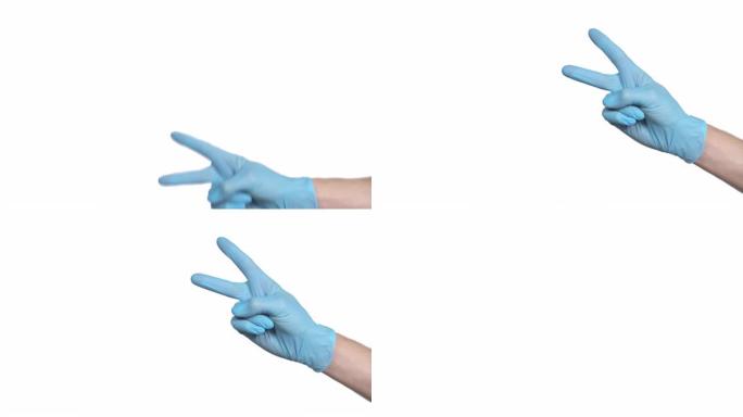 无法识别的医生戴上蓝色防护手套，在框架的右侧显示v字手势。孤立在白色背景上。