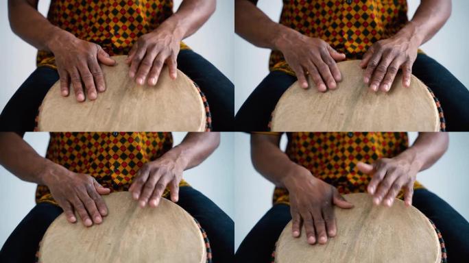 非裔美国人音乐家在家演奏传统鼓的细节。