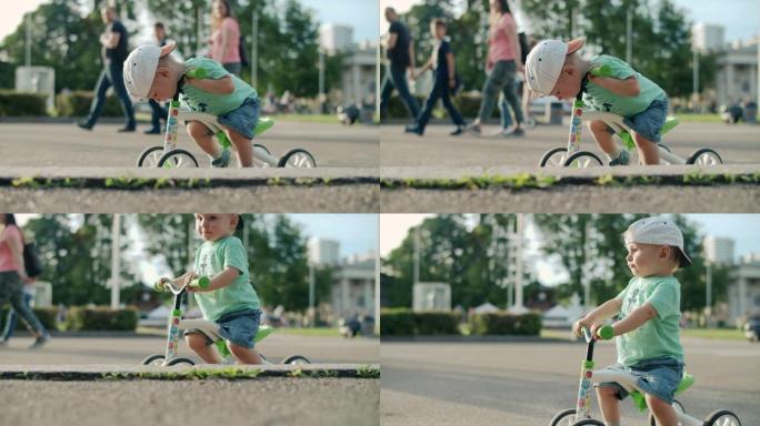 专注的孩子第一次尝试骑自行车。可爱的男孩在游乐园骑自行车