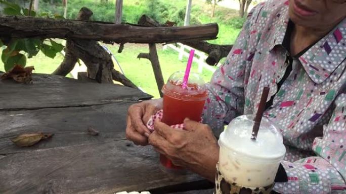 老妇人在咖啡店喝柠檬冰茶