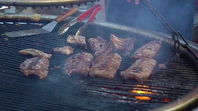 厨师在大烤架上炸肉。烧烤、野餐