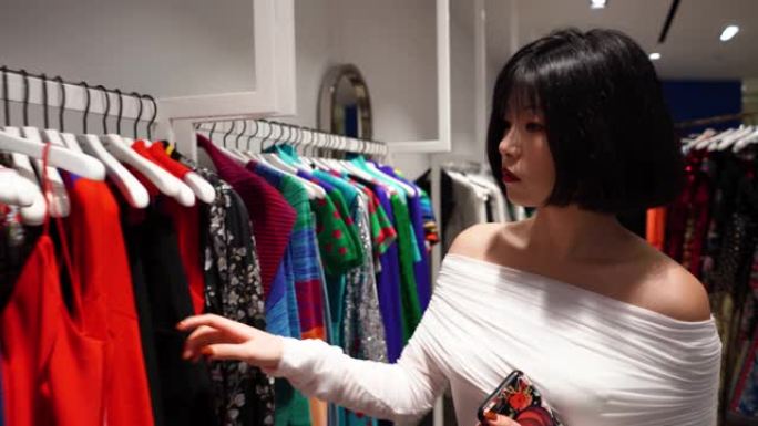 中国女人在商店里买时髦的衣服。