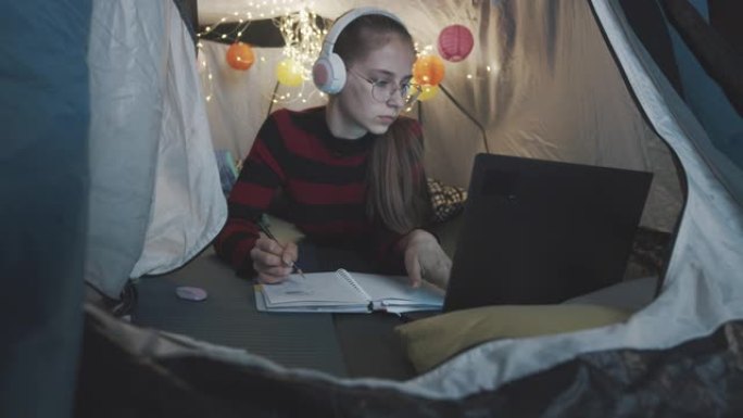 十几岁的女孩在客厅的帐篷里画画