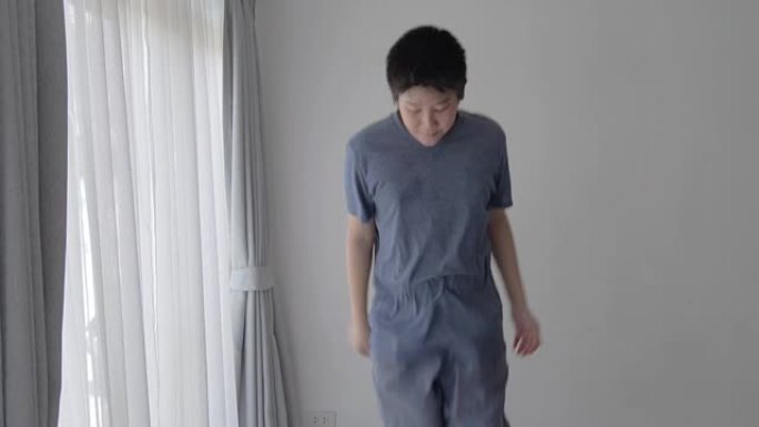 亚洲青春期男孩在家跳上迷你蹦床，健康生活方式理念。