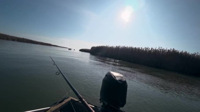 在阳光明媚的天气里，渔夫在美丽的河上的旋转竿上钓鱼，第一人称视角