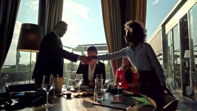 美国黑人女经理在豪华餐厅的商务午餐会上向同事致意