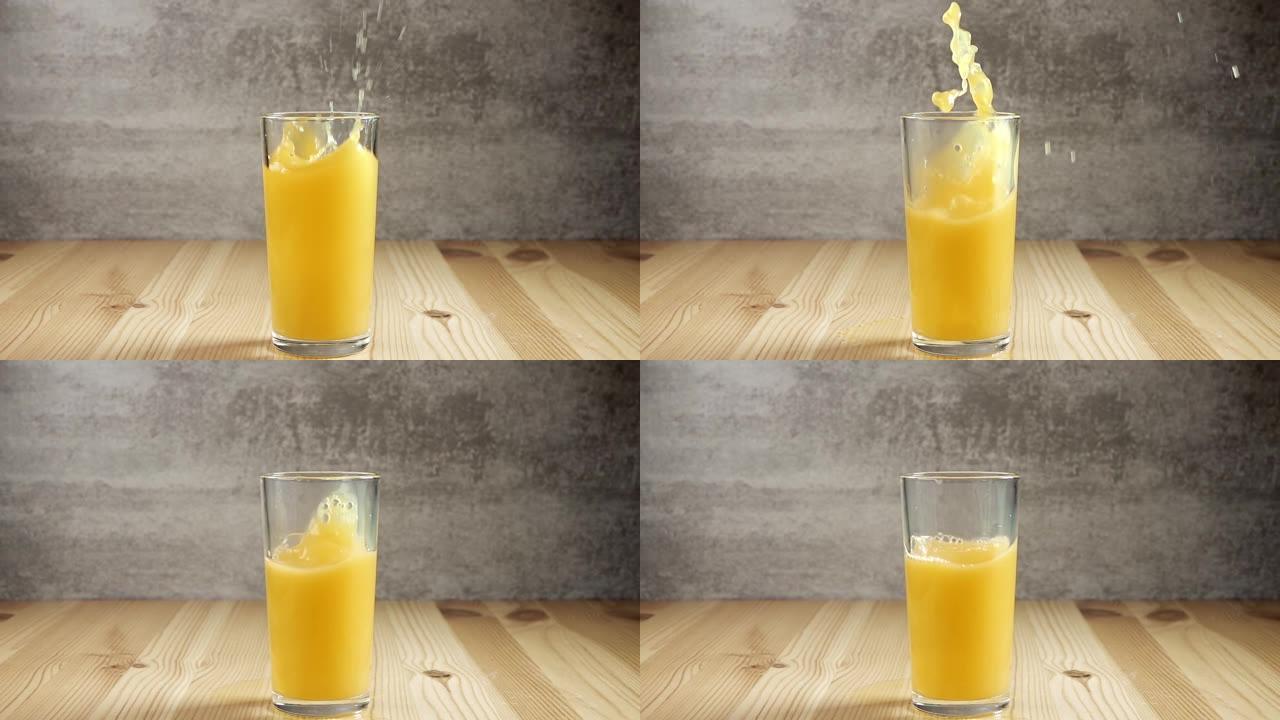 冰块掉入装有橙汁的玻璃杯中。慢动作