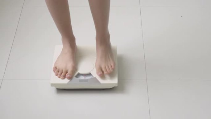 生活方式活动与女性腿站在测量体重秤与赤脚饮食，特写脚的女孩苗条的减肥措施，用于食物控制和营养，健康护