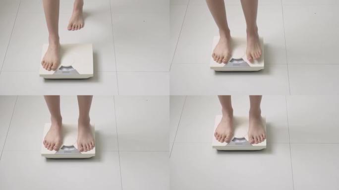 生活方式活动与女性腿站在测量体重秤与赤脚饮食，特写脚的女孩苗条的减肥措施，用于食物控制和营养，健康护